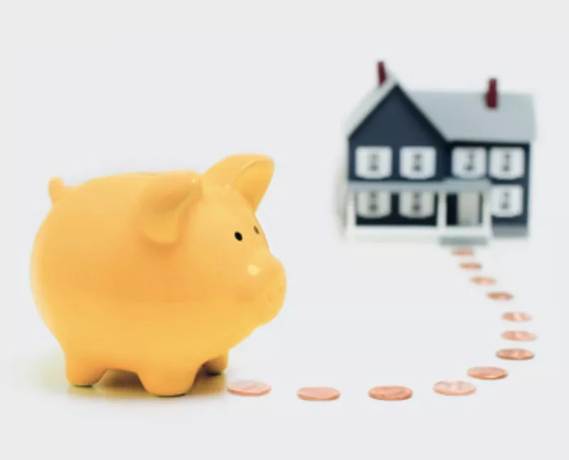 Sparschwein mit ausgelegten Centstücken zu einem Haus
