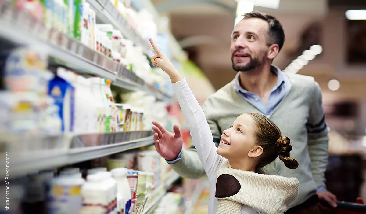 Girl shows a man a product in the refrigerated section
