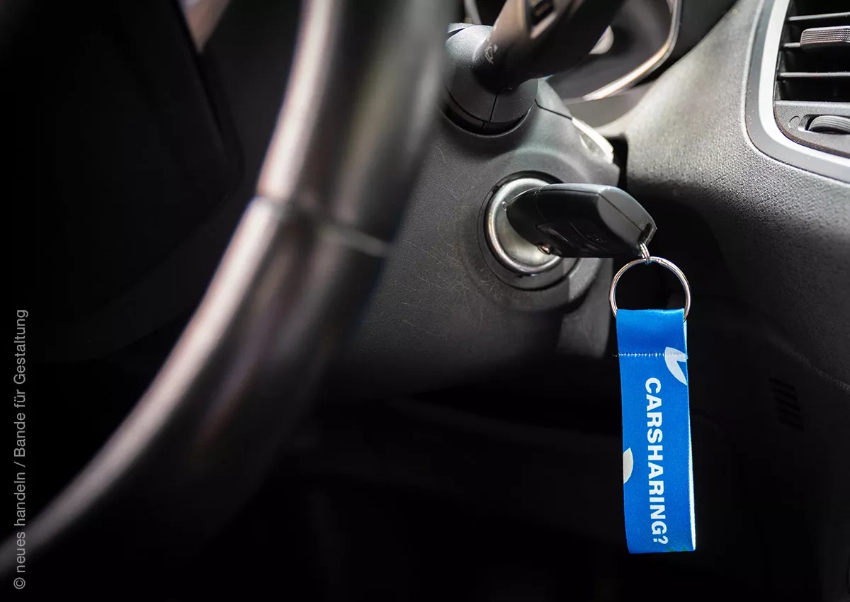 Autoschlüssel mit der Aufschrift Carsharing steckt im Zündschloss