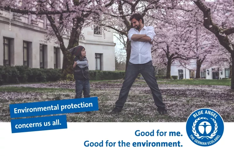 Child and man under Japanese cherry blossoms. Slogan: Environmental protection concerns us all. 