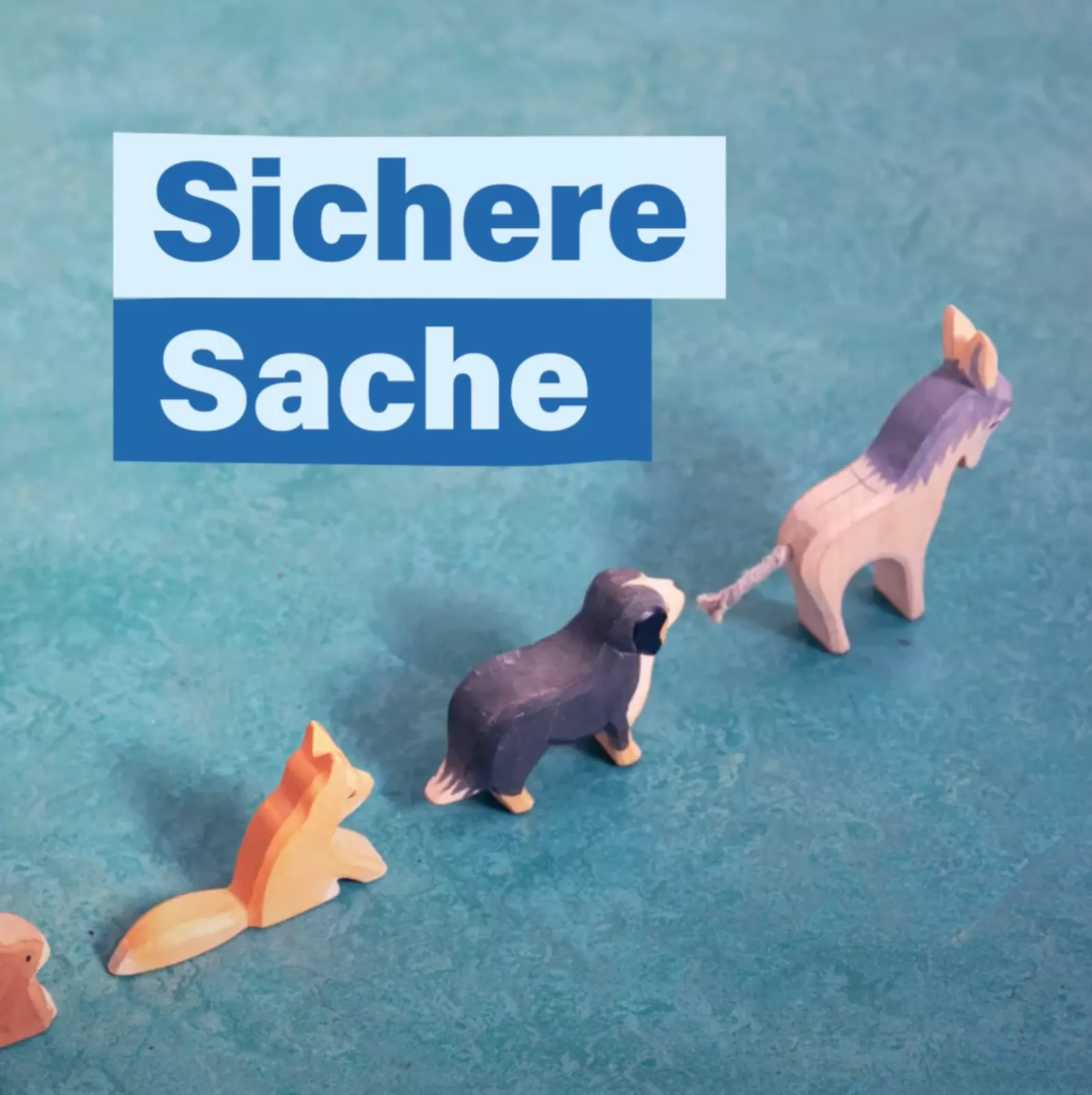 Sichere Sache, Eine Reihe an kleinen Holzfigur-Tieren spaziert nach und nach in einer Reihe durch das Bild