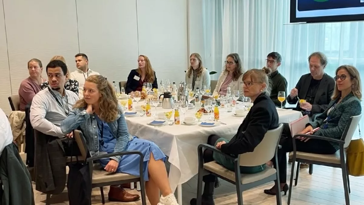 Personengruppe am gedeckten Frühstückstisch