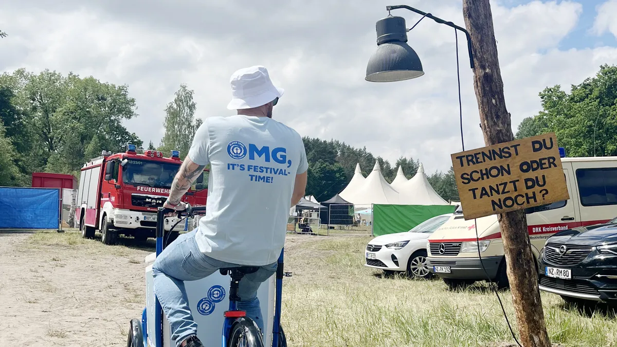 Mann auf Lastenfahrrad, daneben ein Schild mit der Aufschrift "Tanzt Du noch oder trennst Du schon?