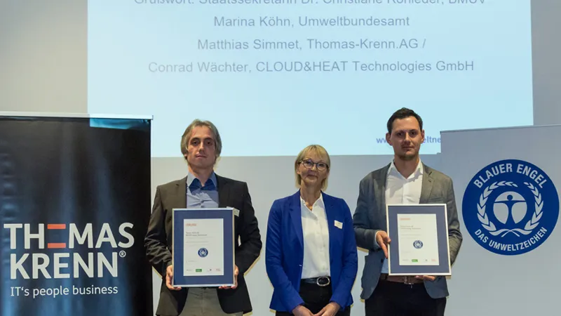 Zwei Stellvertreter der THOMAS-KRENN.AG halten die Urkunden in den Händen, in der Mitte steht Frau Marina Köhn vom Bundesumweltamt